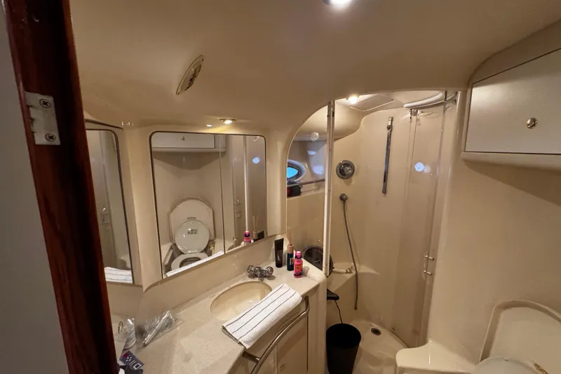 Slide: The Image of Bathroom interior of 1999 Sea Ray 480 Sedan Bridge yacht, featuring shower and vanity. - 32