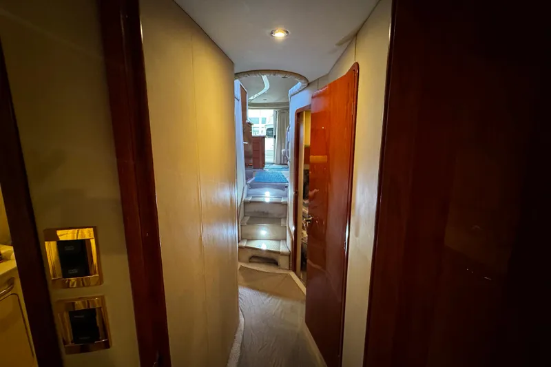 Slide: The Image of Interior hallway of a 1999 Sea Ray 480 Sedan Bridge yacht, featuring wooden doors and carpeted stairs. - 33