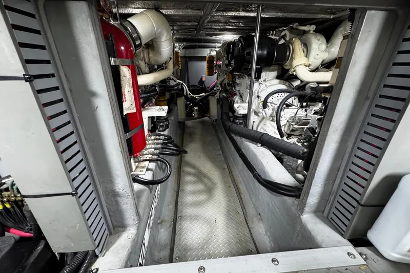 Slide: The Image of Engine room of a 1999 Sea Ray 480 Sedan Bridge, showcasing mechanical components and fire extinguisher. - 34