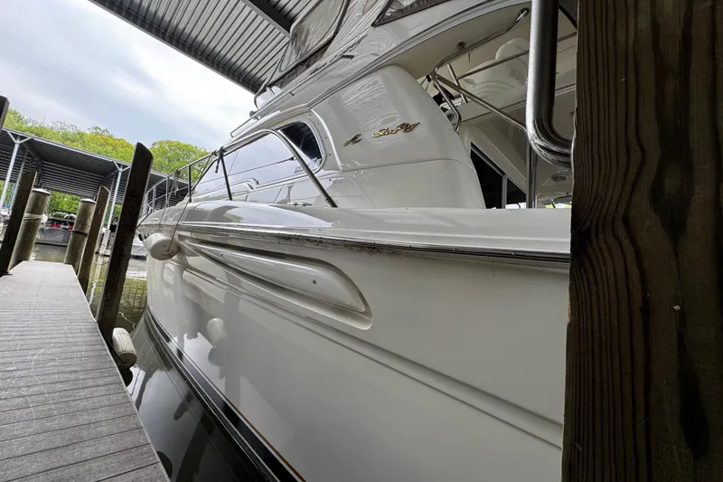 Slide: The Image of 1999 Sea Ray 480 Sedan Bridge yacht docked under a covered marina. - 7