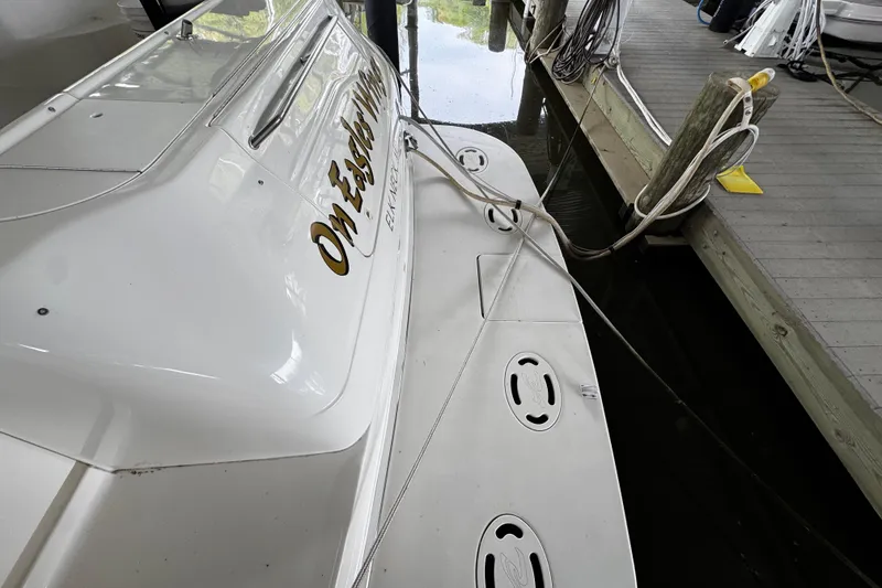 Slide: The Image of 1999 Sea Ray 480 Sedan Bridge docked, showcasing rear deck and mooring lines. - 8