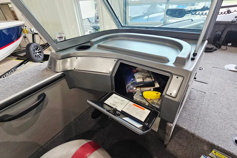 Slide: The Image of Interior of a 2011 Alumacraft Trophy 195 boat showing storage compartment with fishing gear. - 19