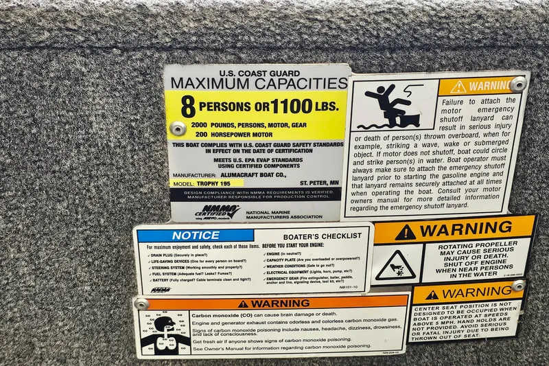 Slide: The Image of Safety and capacity labels on a 2011 Alumacraft Trophy 195 boat, detailing maximum load and warnings. - 23