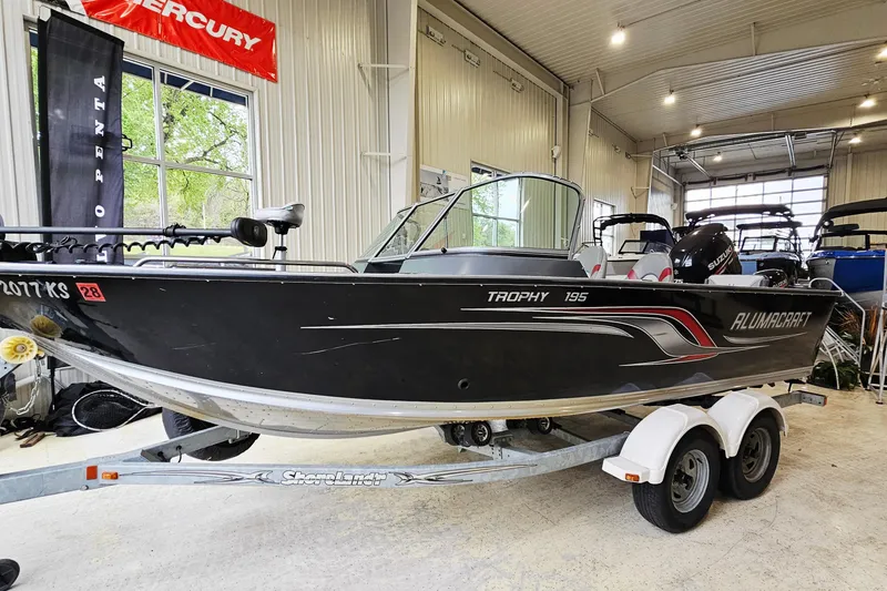Slide: The Image of 2011 Alumacraft Trophy 195 boat on trailer in indoor showroom. - 4