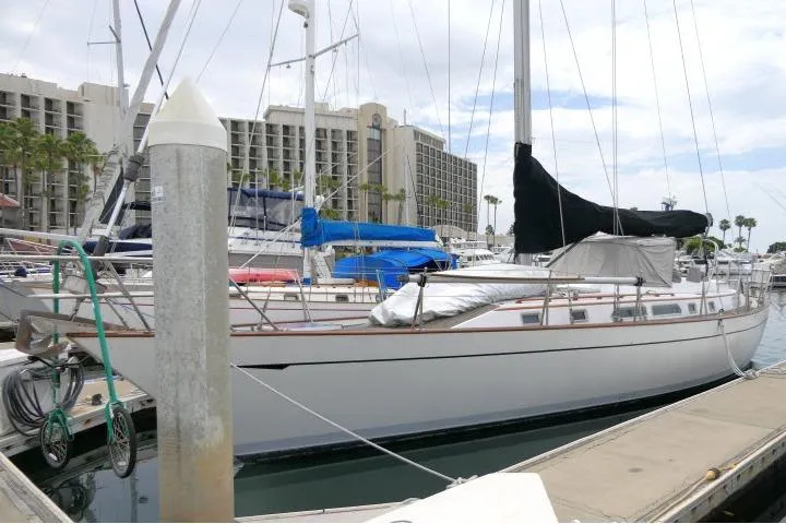 The Image of 1986 Tayana 52 Center Cockpit sailboat docked at a marina, surrounded by other boats. - 1