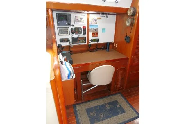 Slide: The Image of 1986 Tayana 52 Center Cockpit navigation station with instruments and wooden desk. - 14