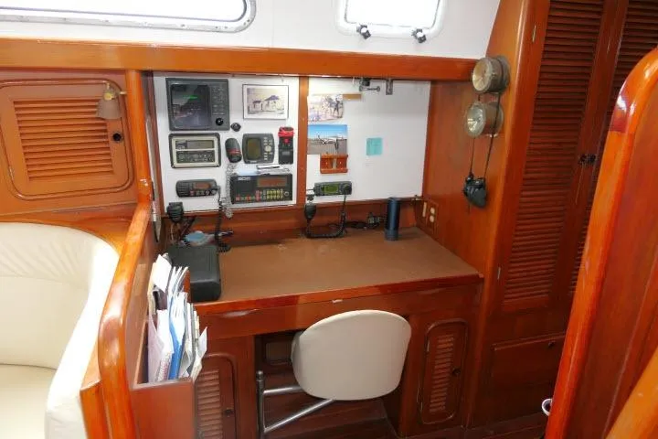 Slide: The Image of Navigation station of 1986 Tayana 52 Center Cockpit yacht with wooden cabinetry and communication equipment. - 15