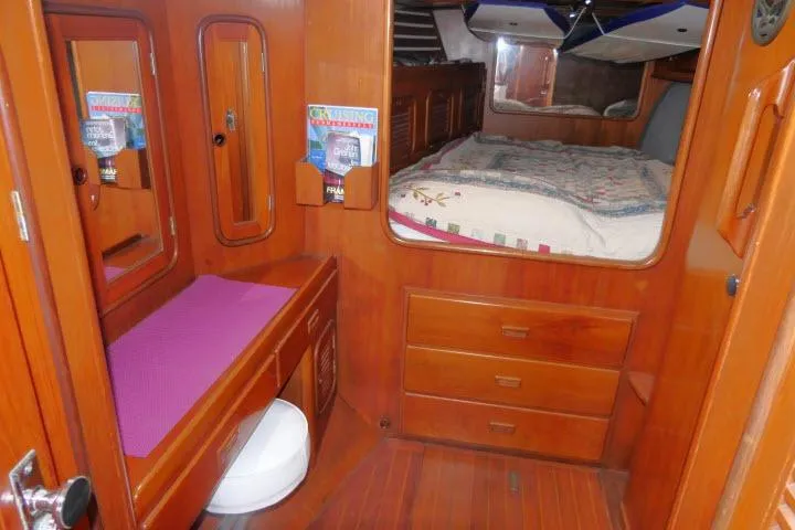 Slide: The Image of 1986 Tayana 52 Center Cockpit interior with wooden cabinetry, bed, and vanity area. - 18
