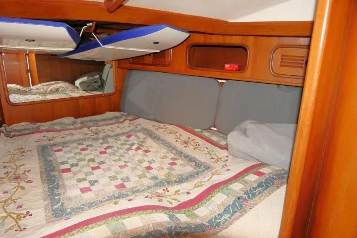 Slide: The Image of Cozy cabin interior of 1986 Tayana 52 Center Cockpit with quilted bedding and wooden accents. - 20