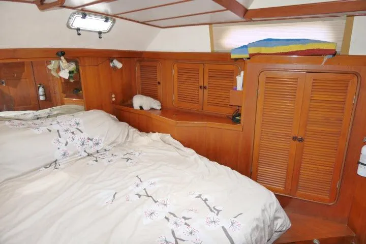 Slide: The Image of 1986 Tayana 52 Center Cockpit bedroom with wooden cabinetry and floral bedding. - 28