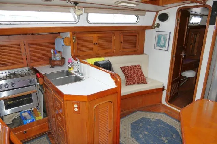Slide: The Image of Interior of 1986 Tayana 52 Center Cockpit yacht with kitchen and seating area. - 3