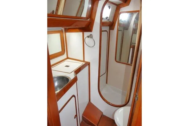 Slide: The Image of 1986 Tayana 52 Center Cockpit yacht bathroom with wood accents and compact design. - 30