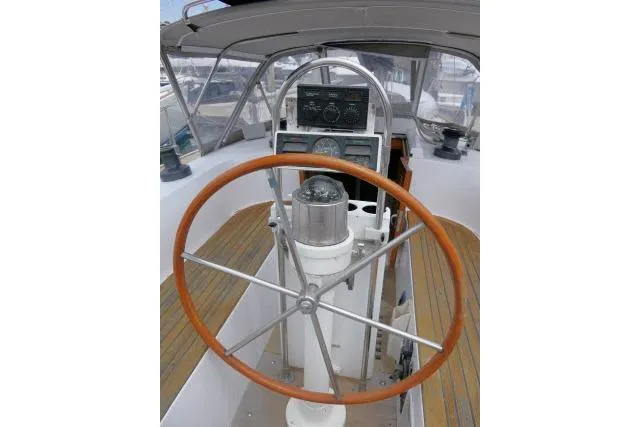 Slide: The Image of 1986 Tayana 52 Center Cockpit sailboat helm with wooden wheel and navigation instruments. - 36