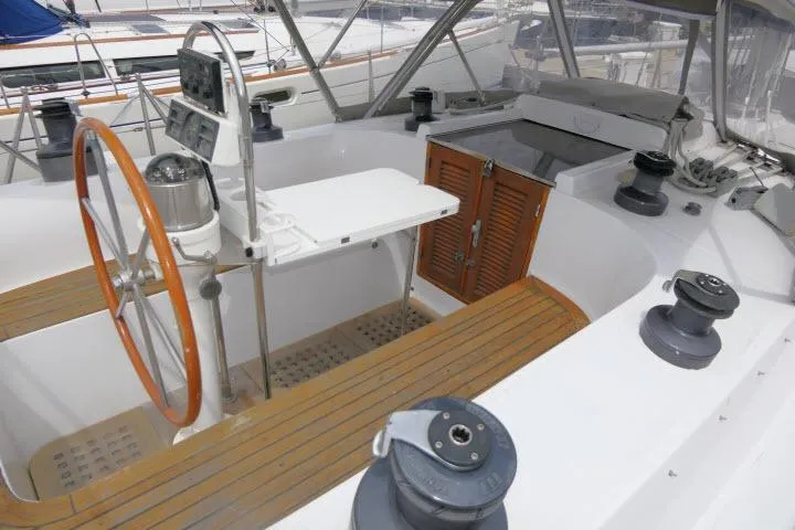 Slide: The Image of 1986 Tayana 52 Center Cockpit with wooden wheel, spacious deck, and modern navigation equipment. - 37