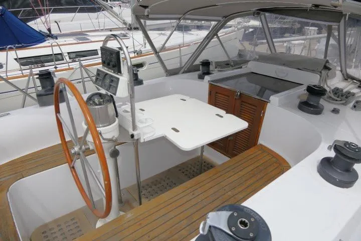 Slide: The Image of 1986 Tayana 52 Center Cockpit sailboat with wooden wheel and spacious seating area. - 38