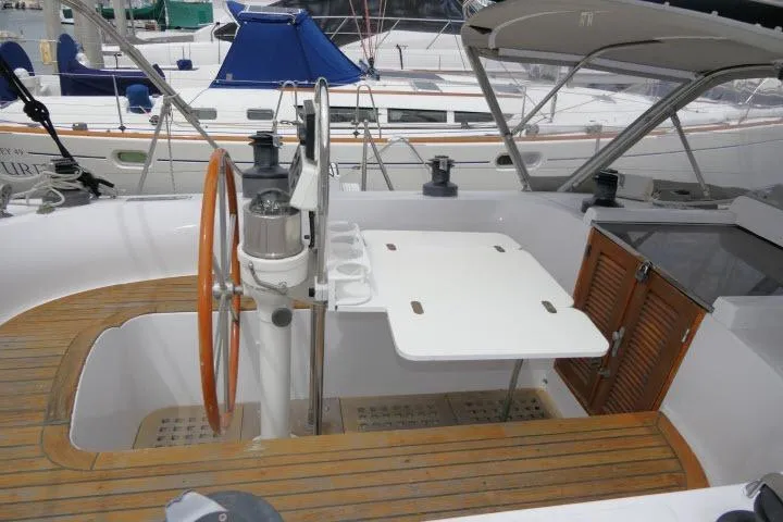 Slide: The Image of 1986 Tayana 52 Center Cockpit sailboat with wooden accents and steering wheel in marina. - 39