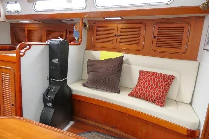 Slide: The Image of Interior of 1986 Tayana 52 Center Cockpit with cushioned seating and guitar case. - 4
