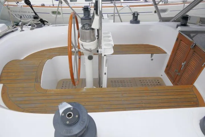 Slide: The Image of 1986 Tayana 52 Center Cockpit with wooden steering wheel and seating. - 40
