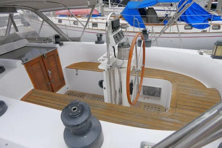 Slide: The Image of 1986 Tayana 52 Center Cockpit with wooden deck and steering wheel in marina setting. - 41