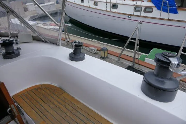 Slide: The Image of 1986 Tayana 52 Center Cockpit sailboat with winches and teak deck in marina setting. - 43