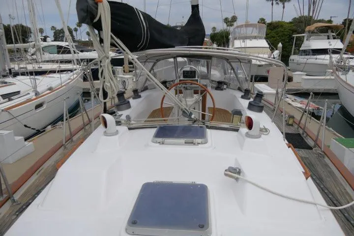 Slide: The Image of 1986 Tayana 52 Center Cockpit sailboat docked at a marina, showcasing its spacious deck and cockpit. - 52