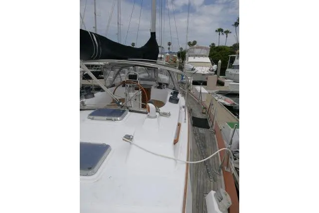 Slide: The Image of 1986 Tayana 52 Center Cockpit sailboat docked, showcasing deck and cockpit area. - 53