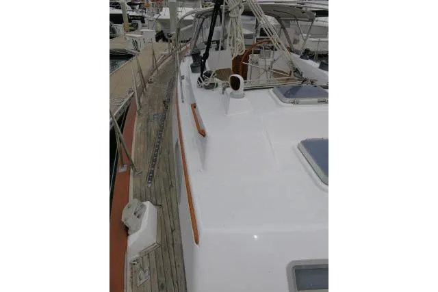 Slide: The Image of 1986 Tayana 52 Center Cockpit sailboat with teak deck and white cabin, docked in a marina. - 54
