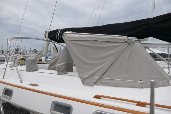 Slide: The Image of 1986 Tayana 52 Center Cockpit sailboat with covered deck, docked at marina. - 63