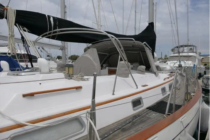 Slide: The Image of 1986 Tayana 52 Center Cockpit sailboat docked at marina, featuring sleek design and spacious deck. - 64