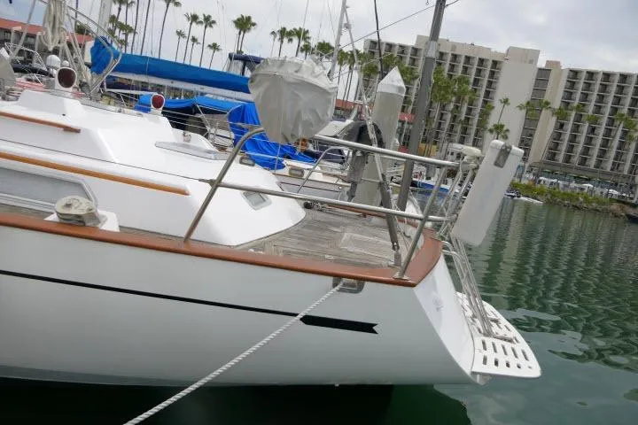 Slide: The Image of 1986 Tayana 52 Center Cockpit yacht docked in marina, surrounded by palm trees and buildings. - 66