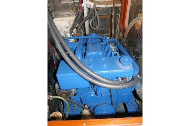 Slide: The Image of Engine of 1986 Tayana 52 Center Cockpit sailboat, painted blue, with visible hoses and wiring. - 68