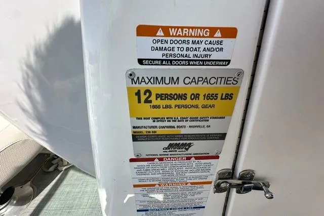 Slide: The Image of Warning and capacity labels on a 2006 Chaparral 236 SSi boat, indicating 12-person limit. - 14