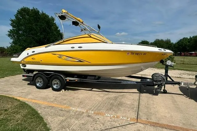 Slide: The Image of 2006 Chaparral 236 SSi boat in vibrant yellow on a trailer, parked outdoors. - 29