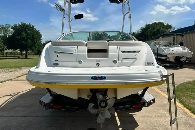 Slide: The Image of 2006 Chaparral 236 SSi boat rear view with ladder and propeller, parked outdoors. - 6