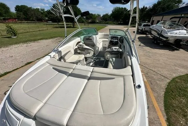 Slide: The Image of 2006 Chaparral 236 SSi boat with spacious seating and sleek design, parked outdoors. - 9