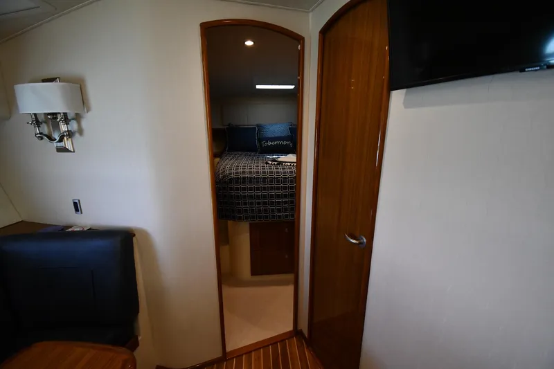 Slide: The Image of Interior cabin view of 2012 Viking 42 Open yacht, featuring cozy bed and elegant wood finishes. - 32