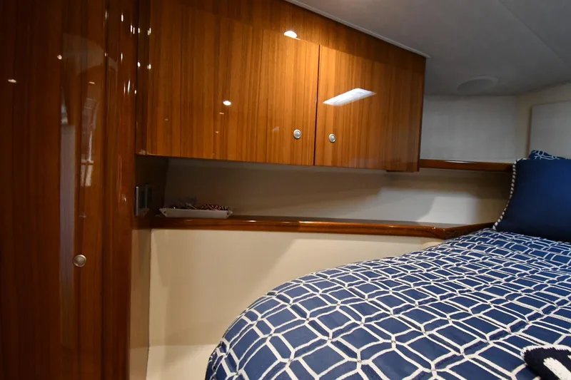 Slide: The Image of Luxurious cabin interior of 2012 Viking 42 Open yacht with wooden cabinets and patterned bedding. - 35