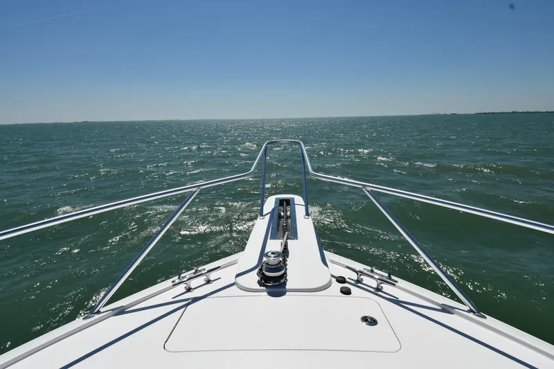 Slide: The Image of Bow view of 2012 Viking 42 Open yacht cruising on open sea under clear blue sky. - 5