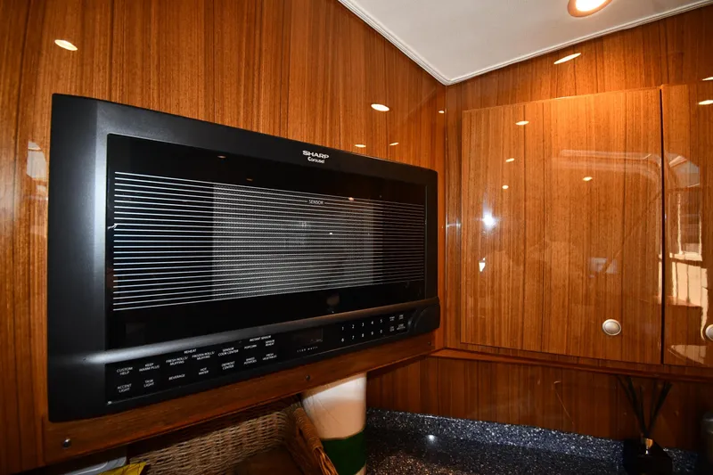 Slide: The Image of Wood-paneled kitchen interior of 2012 Viking 42 Open yacht with built-in Sharp microwave. - 51