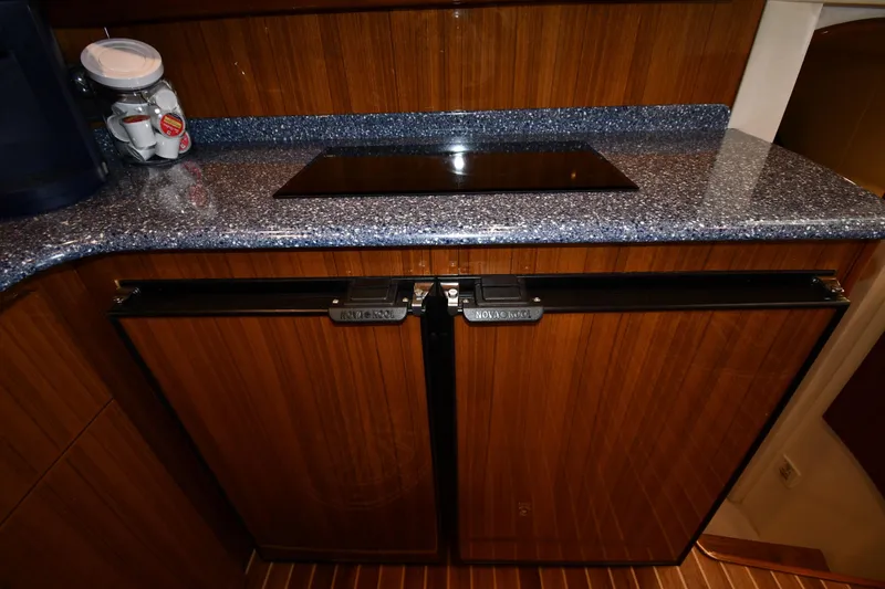 Slide: The Image of Galley kitchen in 2012 Viking 42 Open yacht with wooden cabinets and granite countertop. - 53
