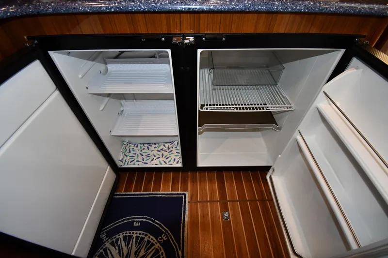 Slide: The Image of 2012 Viking 42 Open yacht interior with open refrigerator, wooden flooring, and countertop. - 54