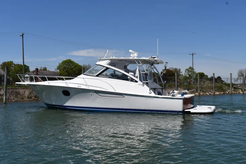 Slide: The Image of 2012 Viking 42 Open yacht cruising on a calm waterway under a clear blue sky. - 62