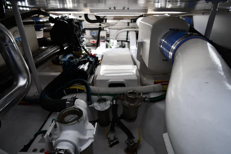 Slide: The Image of Engine room of 2012 Viking 42 Open yacht, showcasing mechanical components and piping. - 78