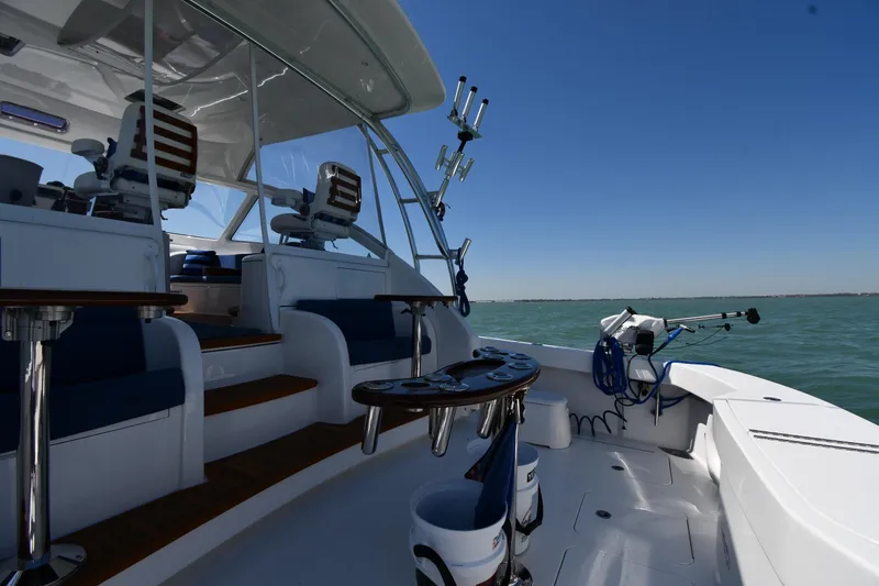 Slide: The Image of 2012 Viking 42 Open yacht interior with seating and fishing equipment on a sunny day. - 9