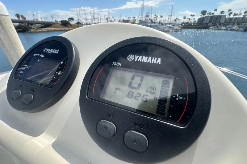 Slide: The Image of Yamaha gauges on a 2016 Zodiac 340 DL boat, docked in a sunny marina. - 8