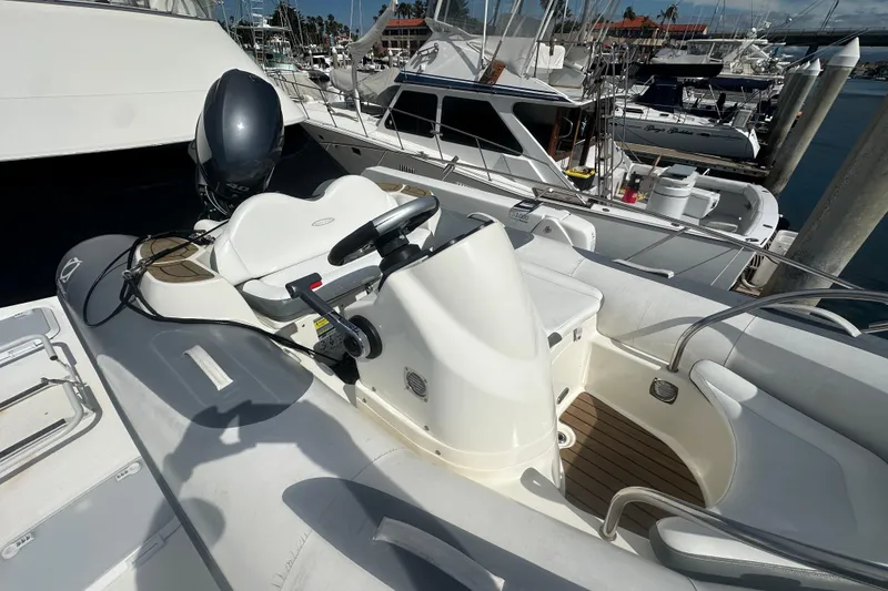 Slide: The Image of 2016 Zodiac 340 DL inflatable boat docked at marina, featuring steering console and outboard motor. - 9