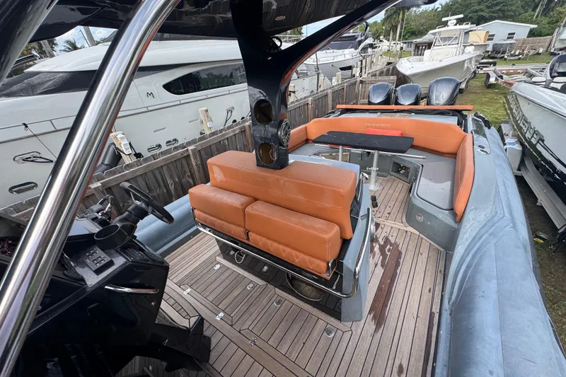 Slide: The Image of 2019 SACS Strider 13 OB boat interior with orange seating and wooden deck. - 5