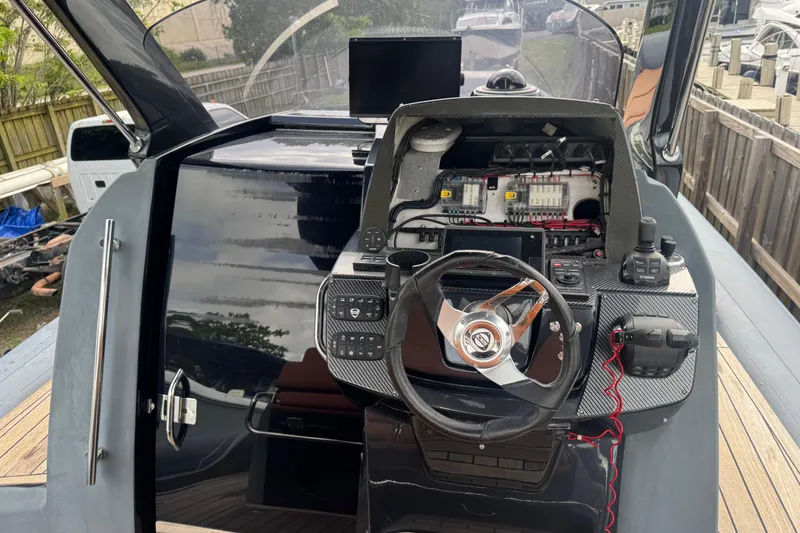 Slide: The Image of 2019 SACS Strider 13 OB boat cockpit with steering wheel and control panel. - 6