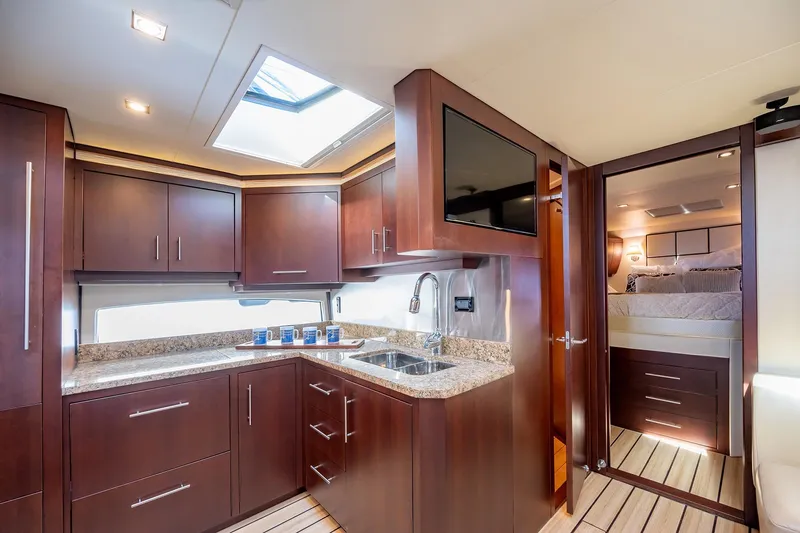 Slide: The Image of Luxurious interior of 2015 Regal 53 Sport Coupe yacht with modern kitchen and cozy bedroom. - 15