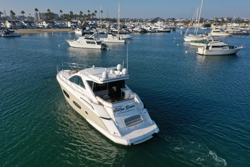 Slide: The Image of 2015 Regal 53 Sport Coupe yacht cruising in a marina with other boats. - 4